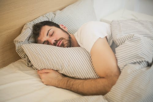 a man sleeping while clutching the pillow