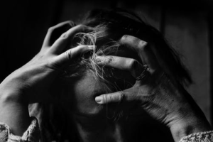 A stressed-out woman holding her head