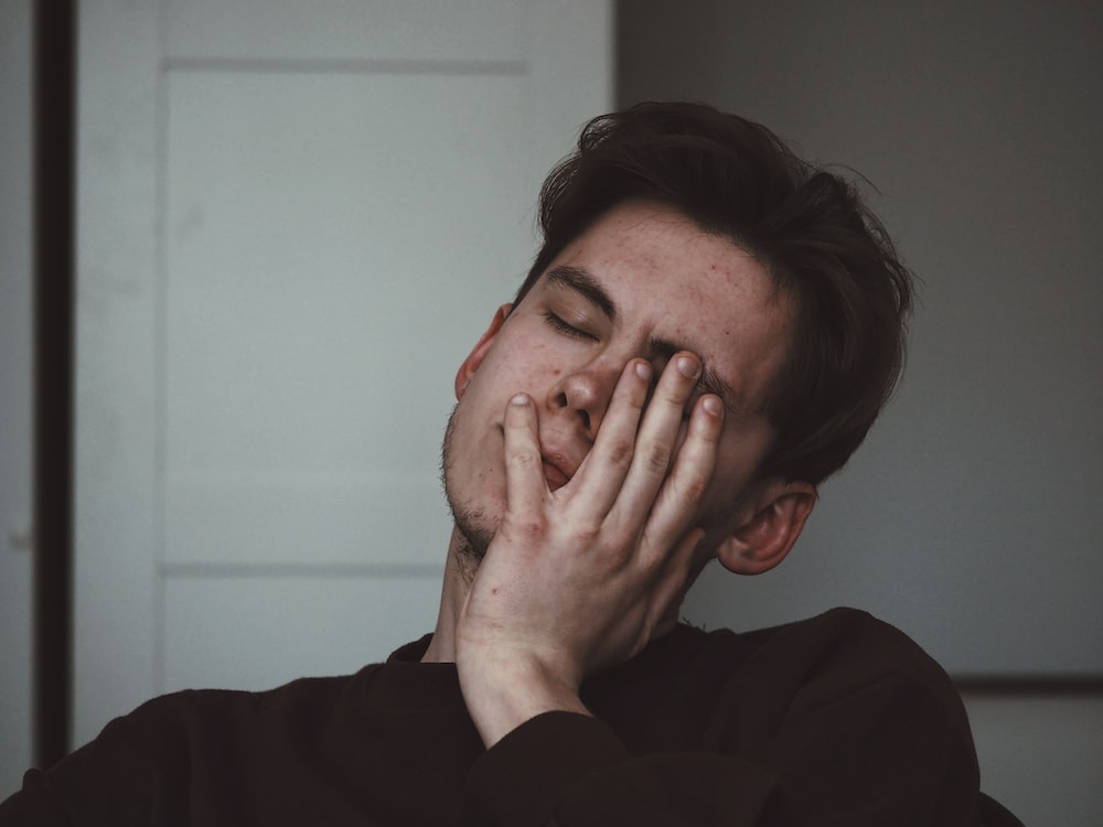 A man in a black shirt looking tired.