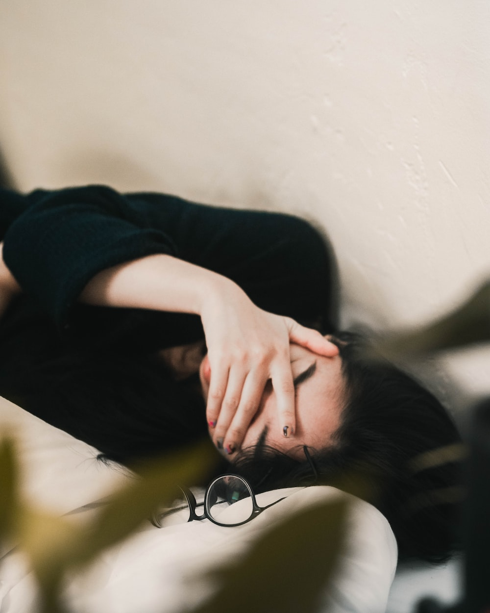 a woman lying down with her hand on her face.