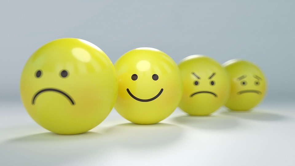 Four yellow balls depicting faces with varying emotions